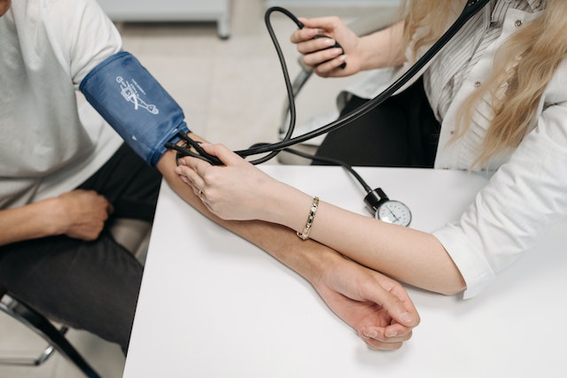Professional taking patient's blood pressure for allied health jobs