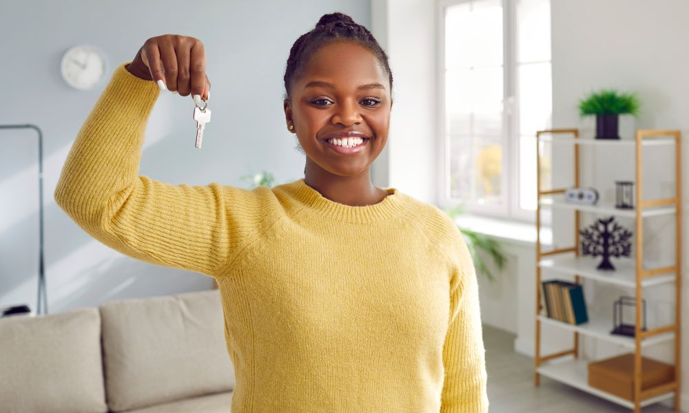 woman smiling and holding key to housing for allied health travel jobs