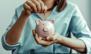 woman in allied health travel jobs saving money in piggy bank